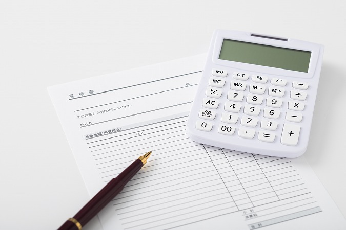 見積書と電卓と蓋が外れたペン